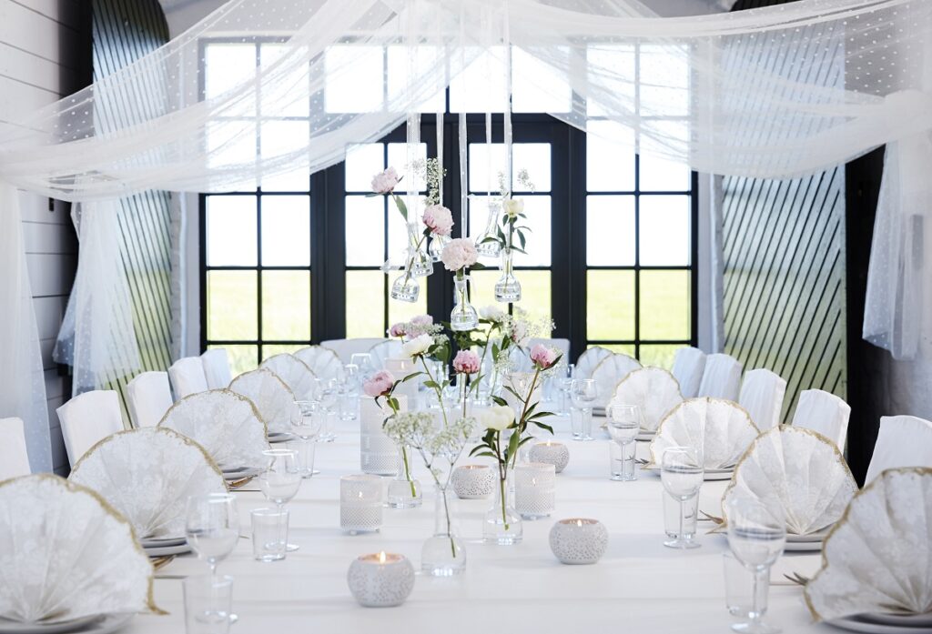 Edles Restaurant im Nürnberger Land: Große, festlich gedeckte Tafel mit kunstvoll gefalteten, weißen Duni-Servietten mit Goldrand.